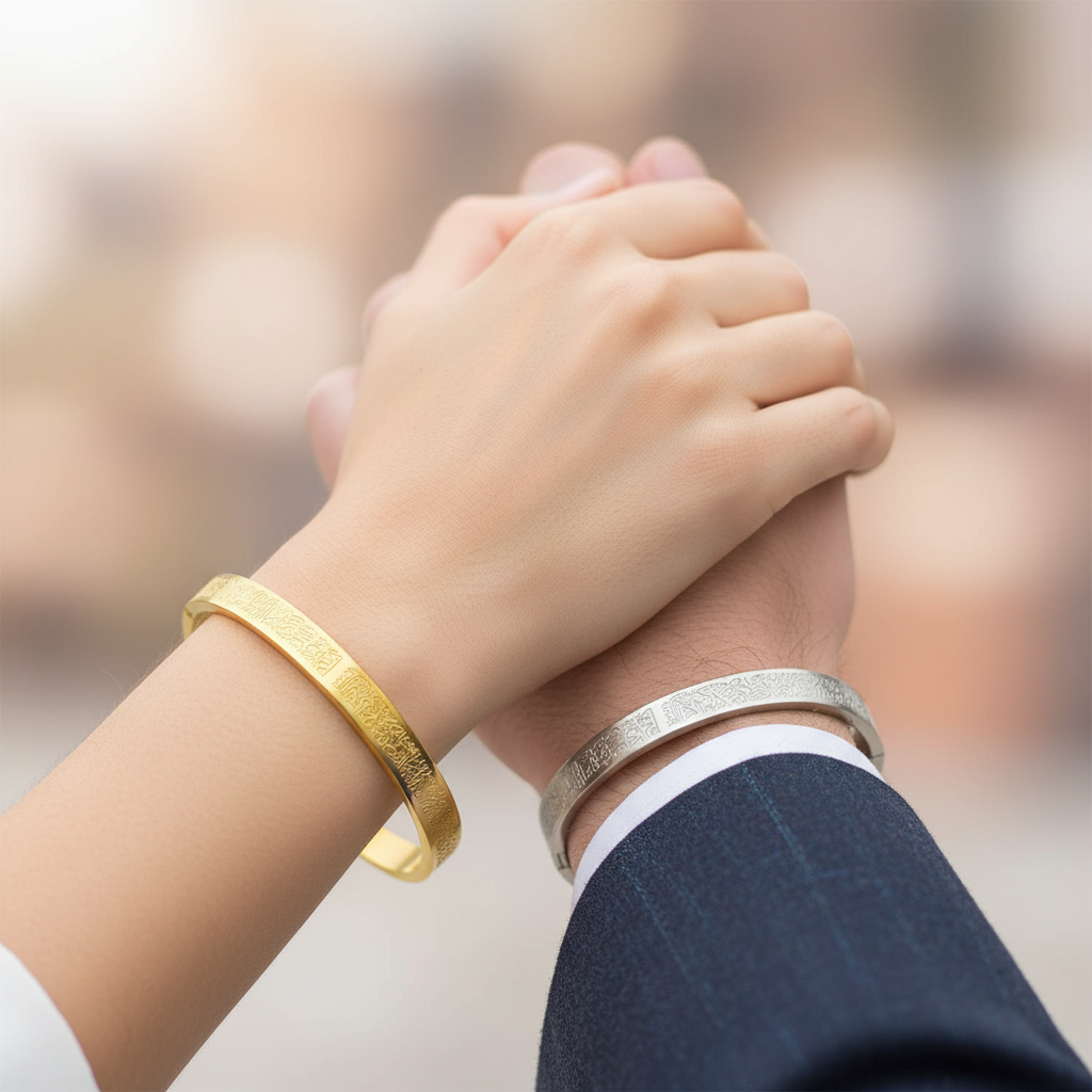 Couple holding hands - woman with gold Ayat al-Kursi bracelet, man with silver, text visible
